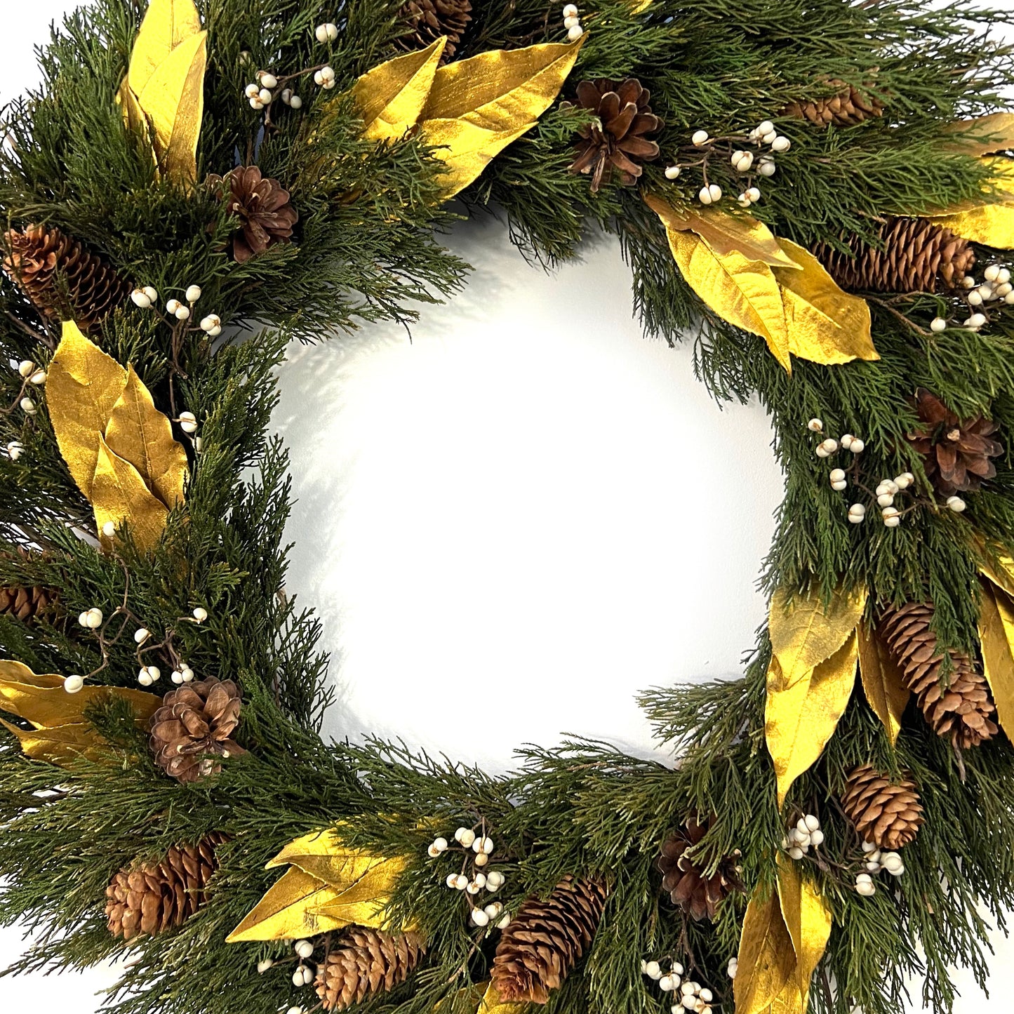large preserved juniper wreath with luxurious gold and white accent decorated with pinecones