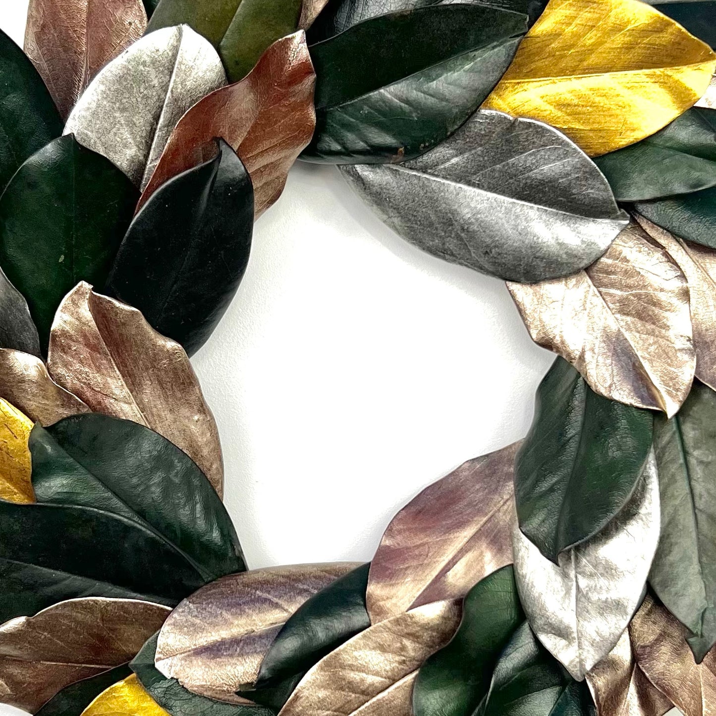 center of the preserved magnolia wreath with dark green, gold and silver painted leaves for home decor