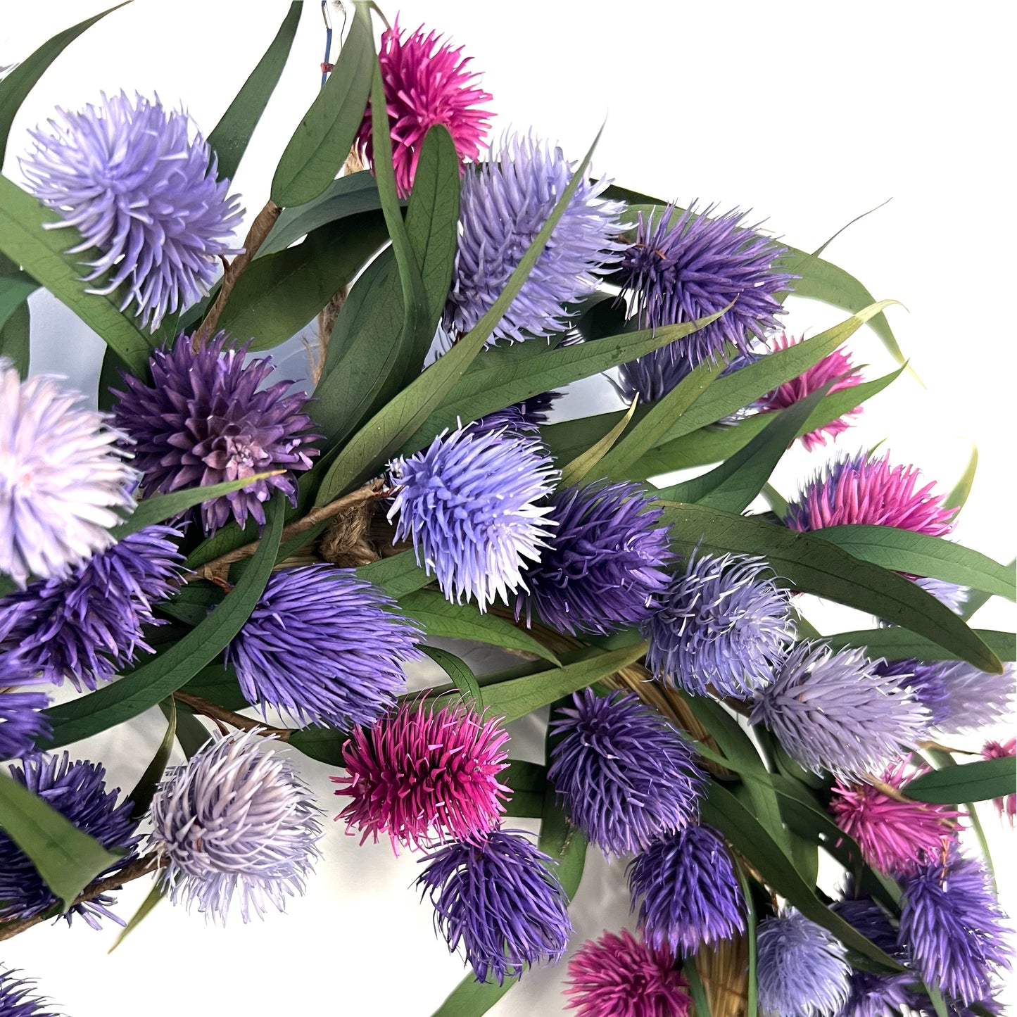 closeup look of the dried pink and purple platycarya balls on the natural wreath