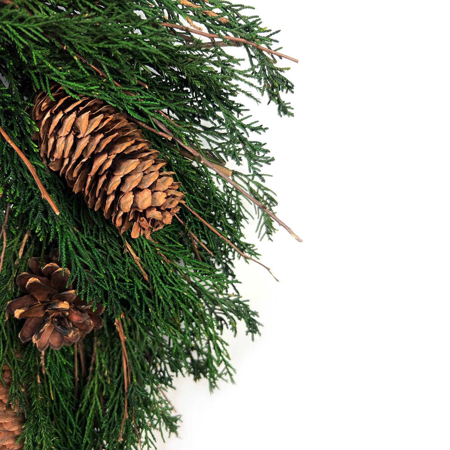 closeup look of the pinecones and twig elements on the preserved juniper wreath