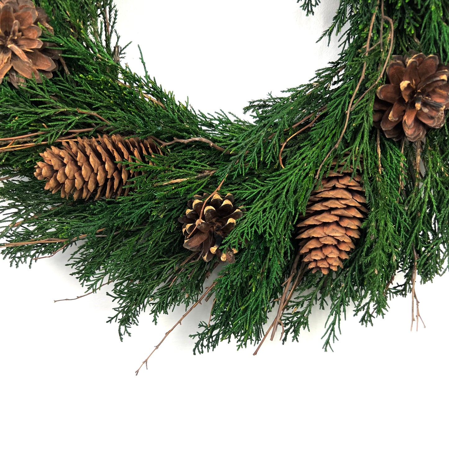 lower half of the preserved christmas wreath with a closeup look at the pinecones