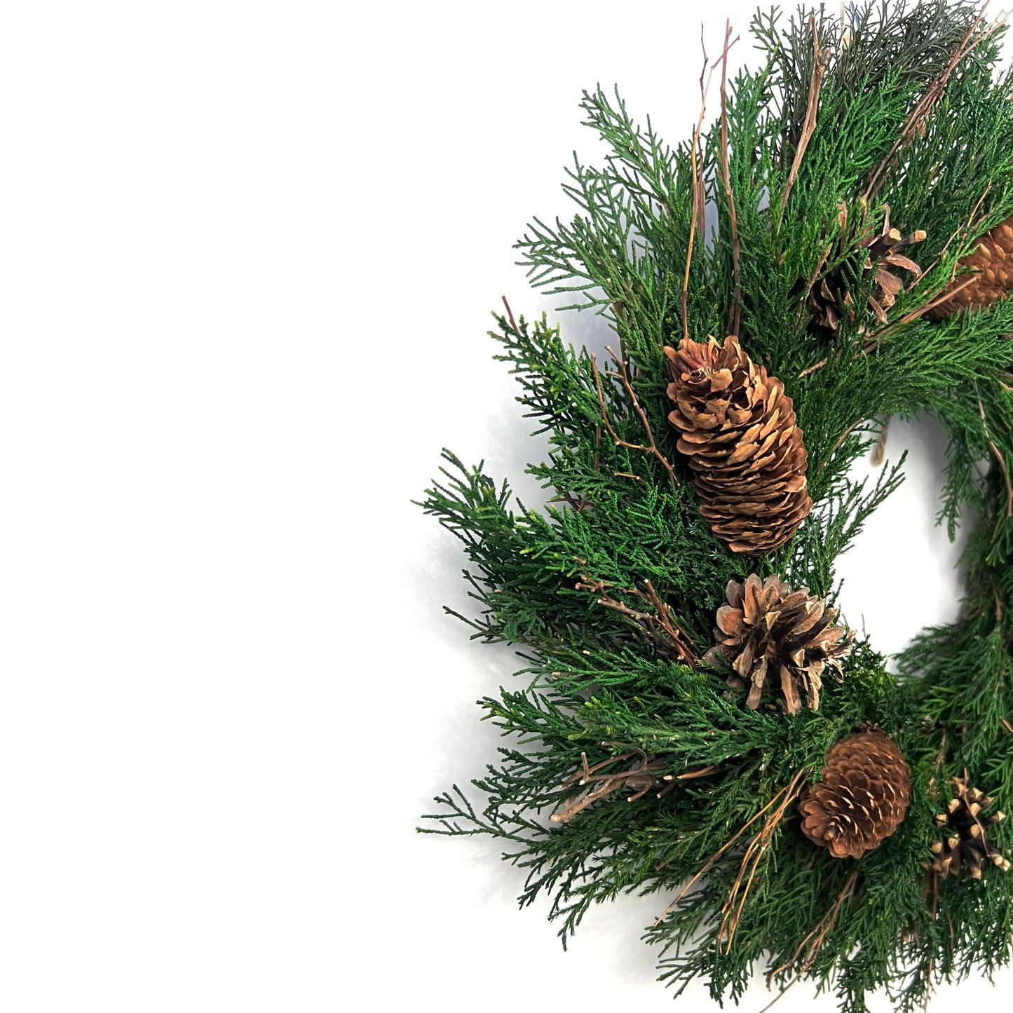 side view of preserved natural wreath with juniper and pinecones for winter decorations