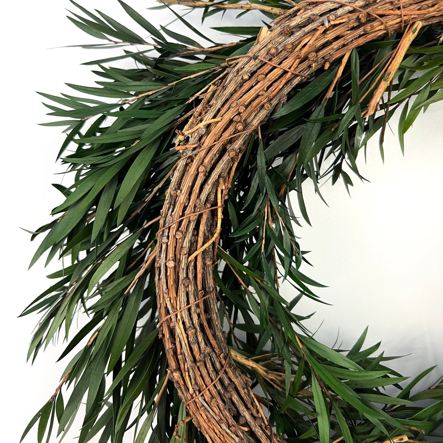 the back of the preserved bottlebrush leaf wreath made from dried pine twigs