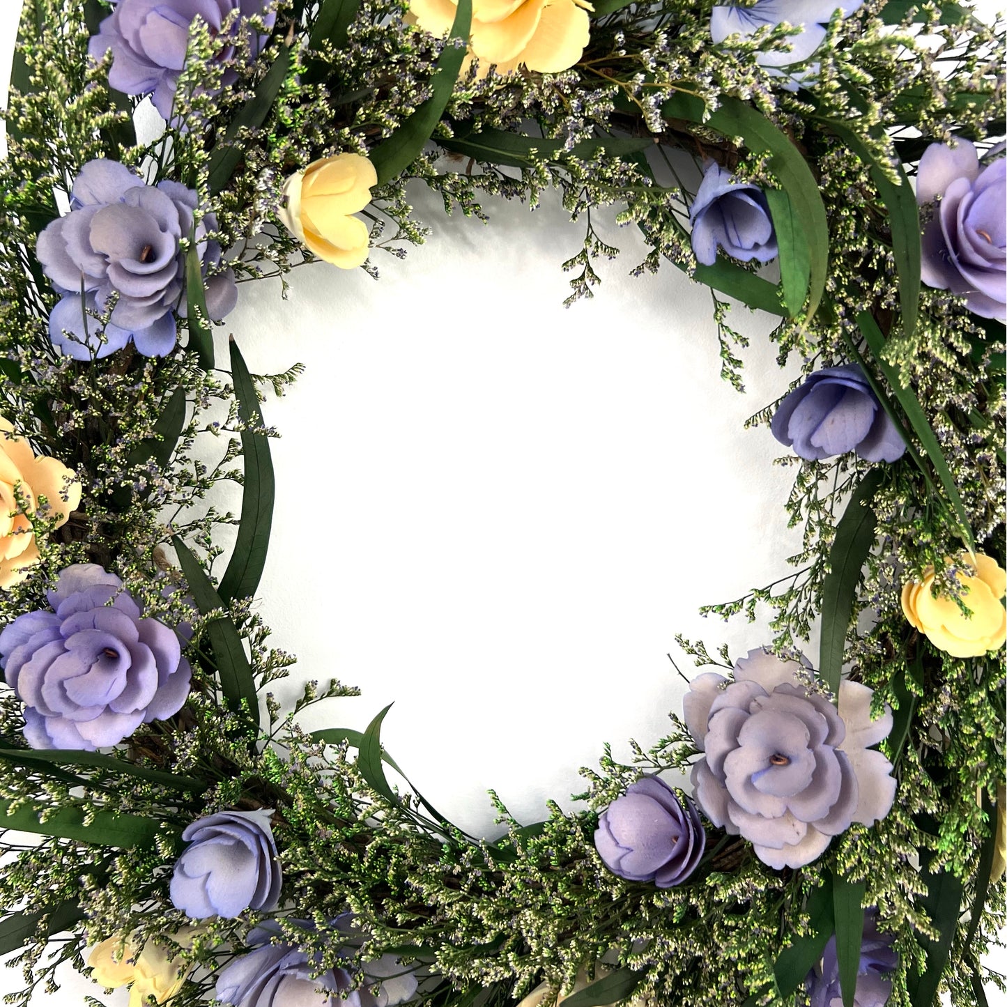 center of the preserved eucalyptus wreath with handmade flowers made from wood chips