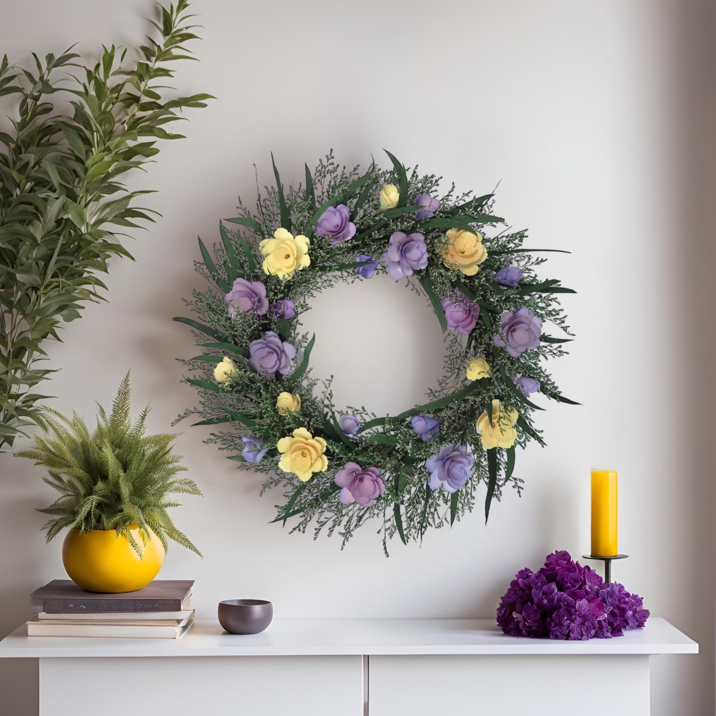 preserved spring wreath with eucalyptus hanging on a white wall above a white desk decorated with purple and yellow decors