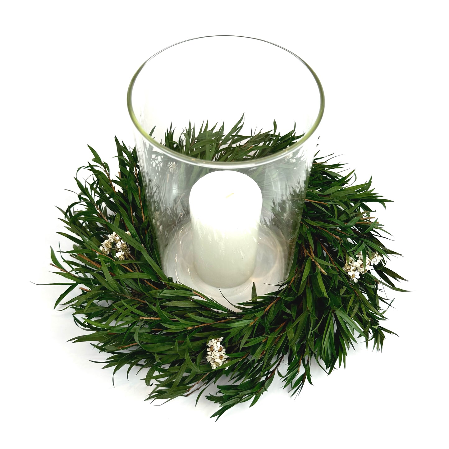 Top view of preserved candle ring wreath with daisy flowers around a glass candle holder