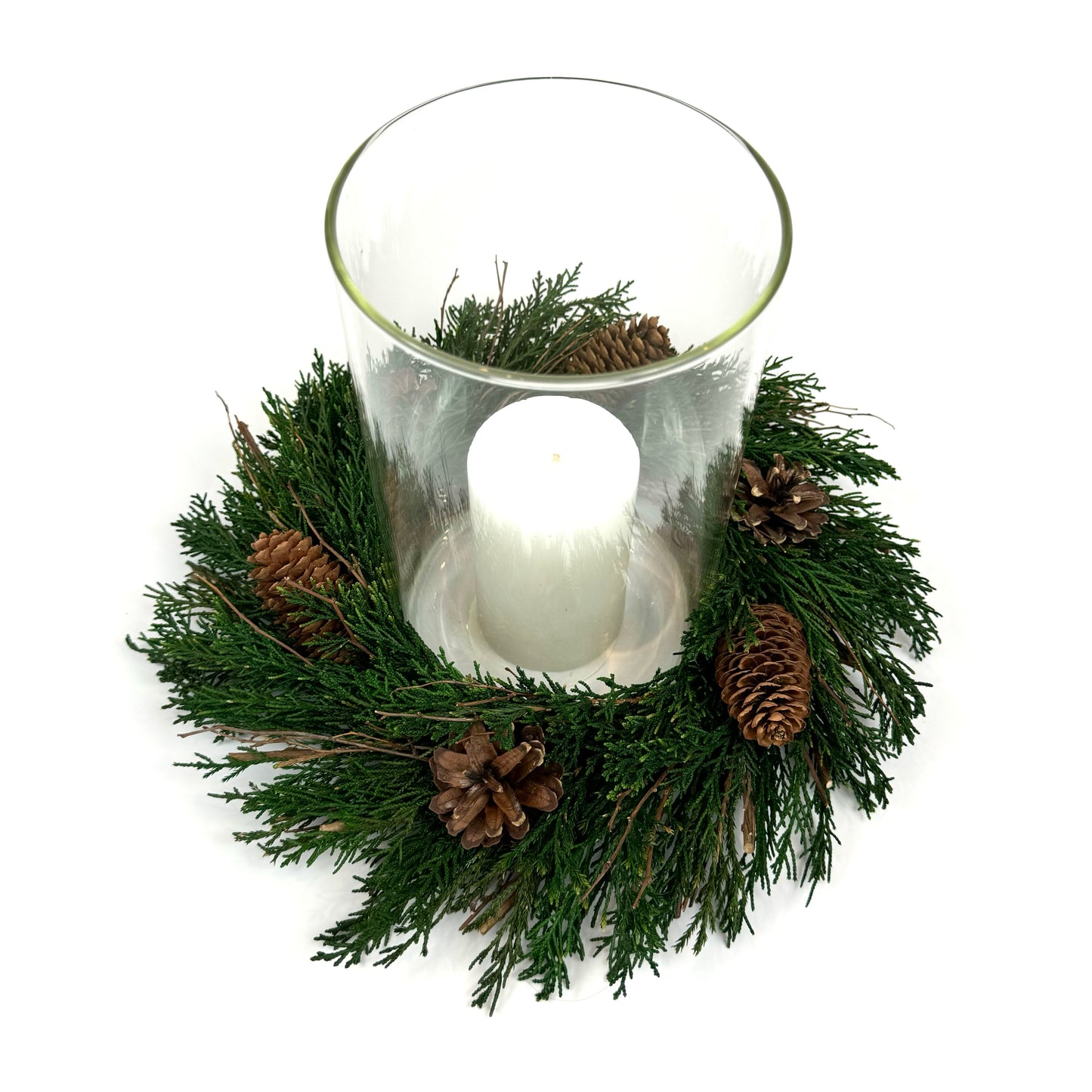 Top view of preserved candle ring wreath with pinecones around a glass candle holder cylinder