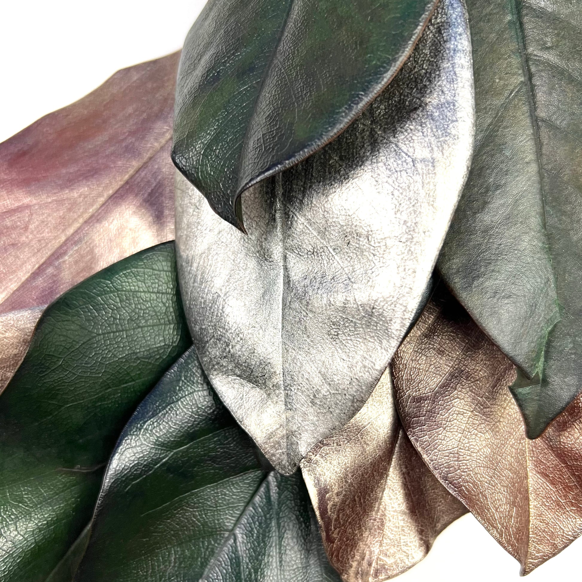 closeup look of the painted silver and copper tone magnolia leaves on the wreath