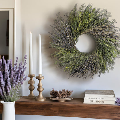 purple preserved wreath hanging above a table with tapered candles and books on it