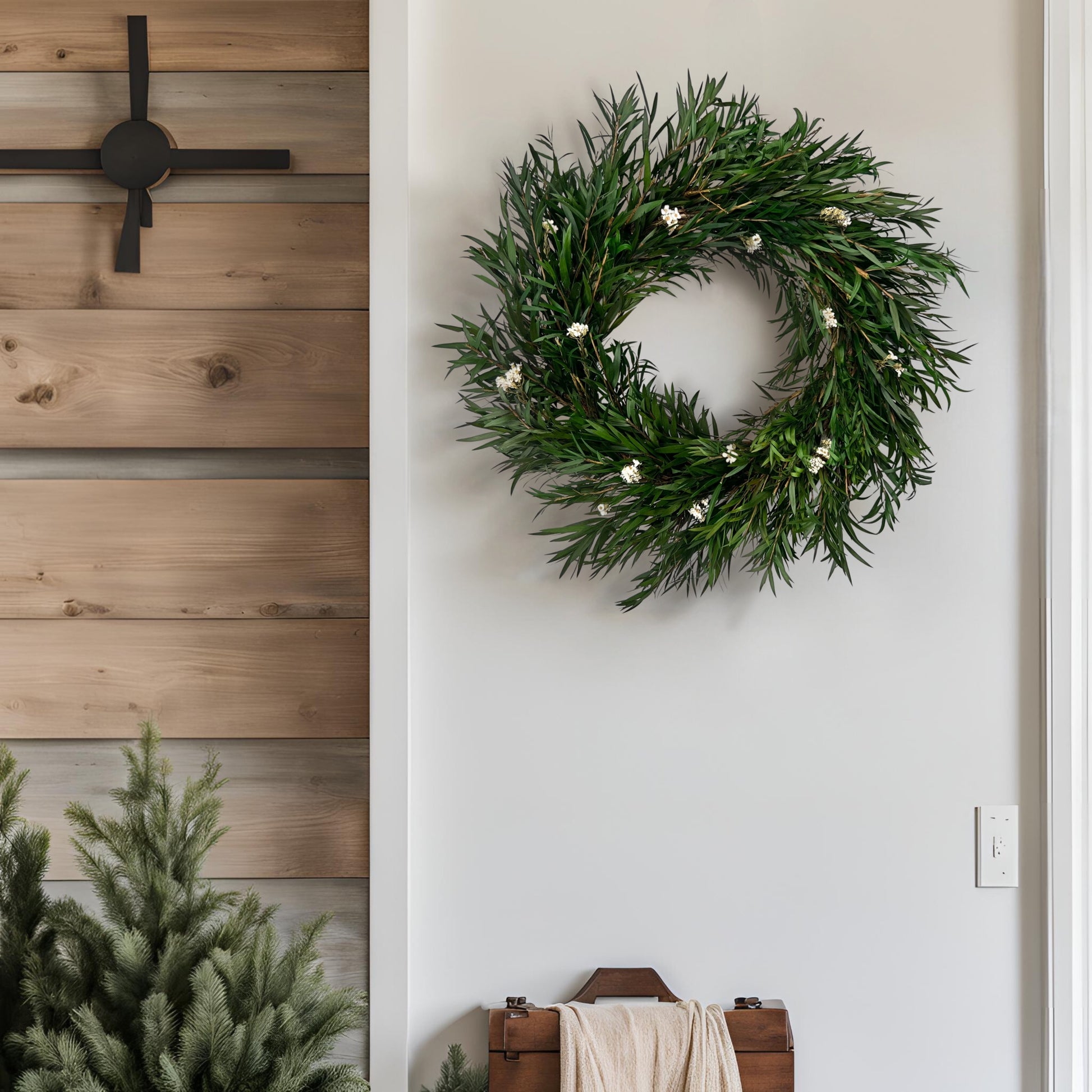 preserved bottlebrush leaf wreath on a white wall surrounded by farmhouse decorations