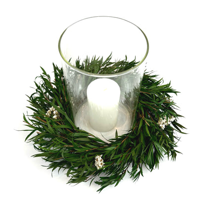 Top view of preserved candle ring wreath with daisy flowers around a glass candle  holder