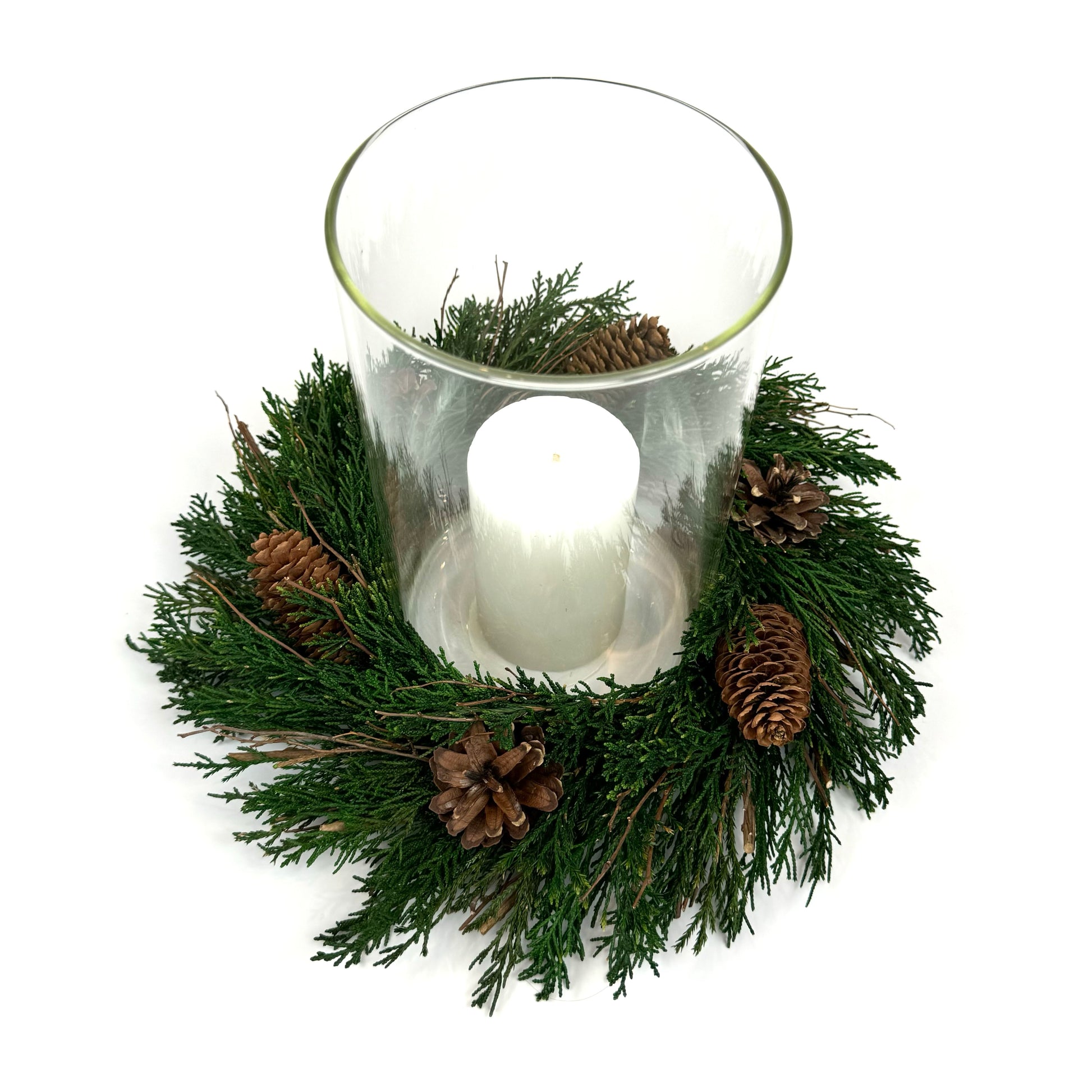 Top view of preserved candle ring wreath with pinecones around a glass candle  holder cylinder